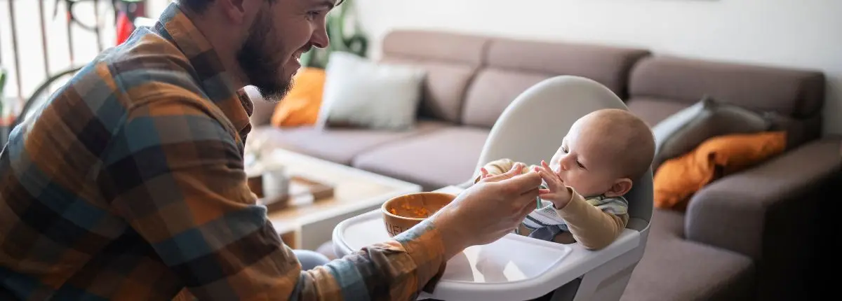 Un papà aiuta un bambino a mangiare