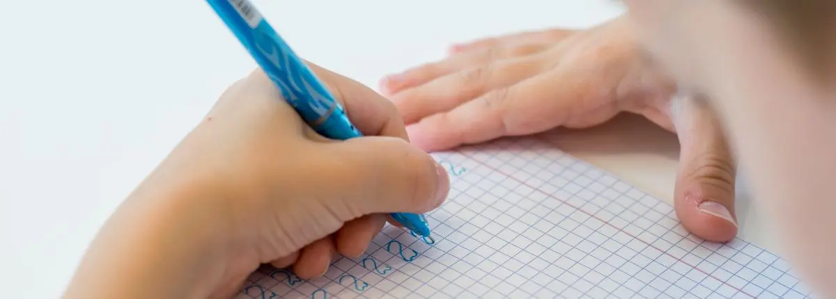 Back to school creativo e sostenibile: un bambino scrive sul quaderno scolastico