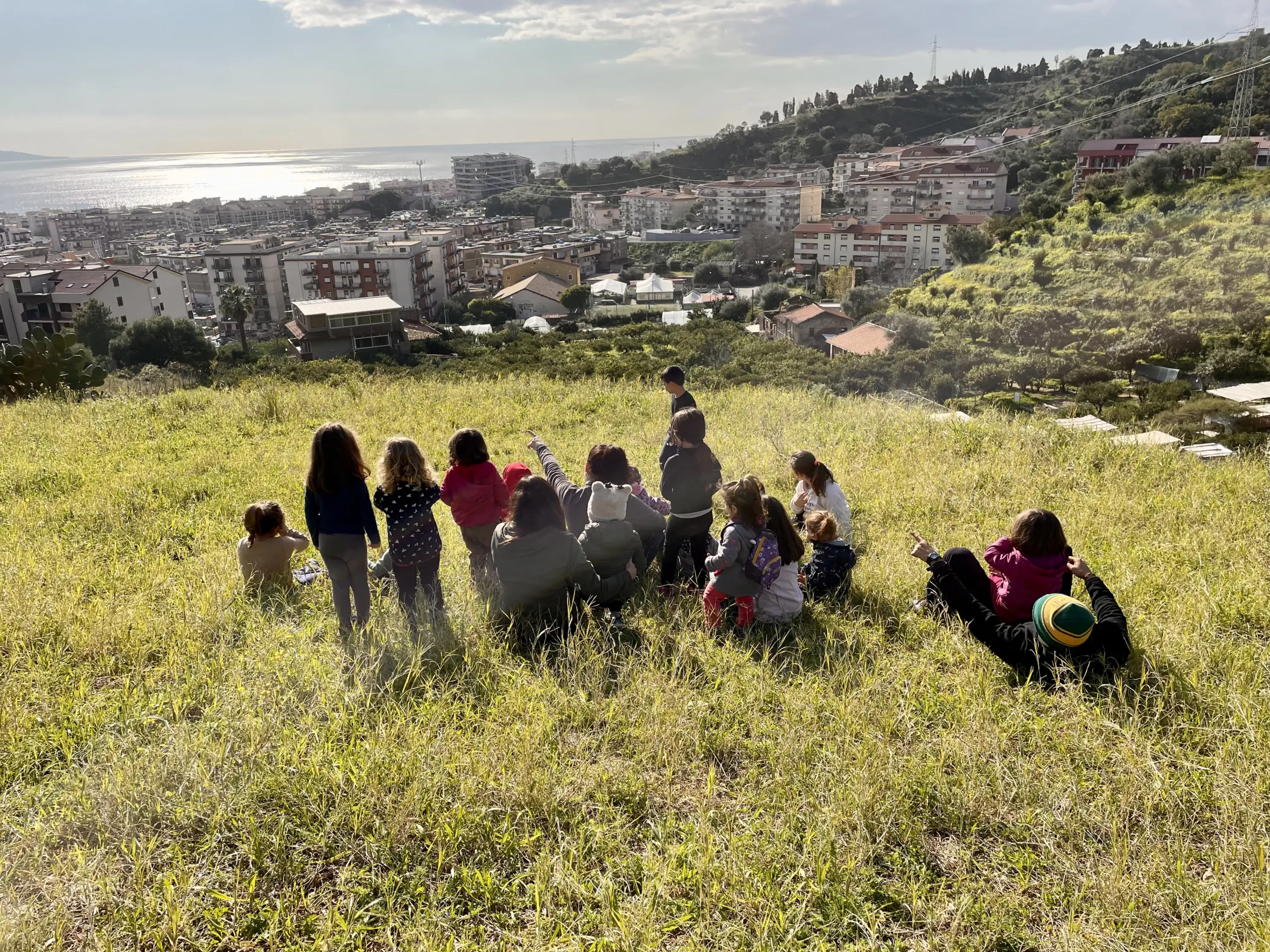 Un gruppo di bambini osserva il paesaggio di Messina dal glamping VIllarè 