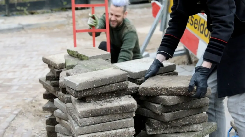 Un volontario che prepara le piastrelle da scambiare con altri che possono utilizzarle in progetti verdi