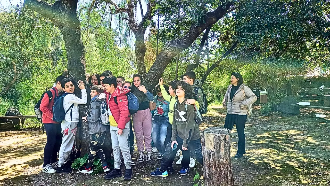 Io Lilly Cacace, educatrice ambientale: n gruppo di bambini sotto un grande albero