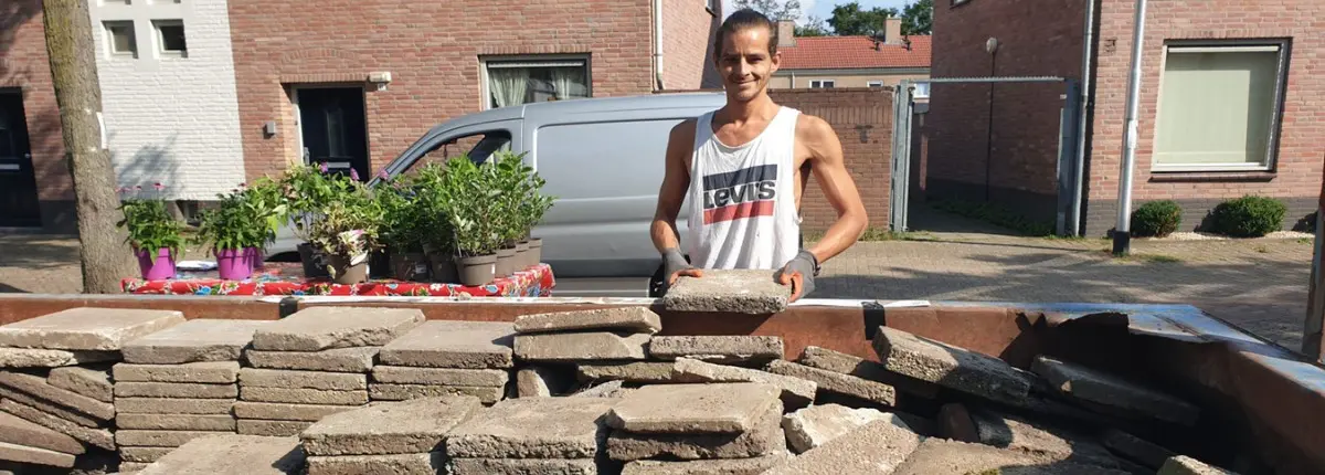 La rivoluzione delle piastrelle: un volontario davanti a decine di piastrelle rimosse