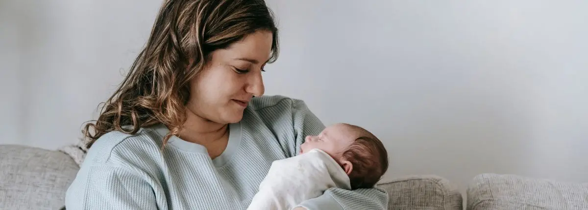 Svezzamento, quando iniziare e come gestirlo: una mamma con il bambino in braccio