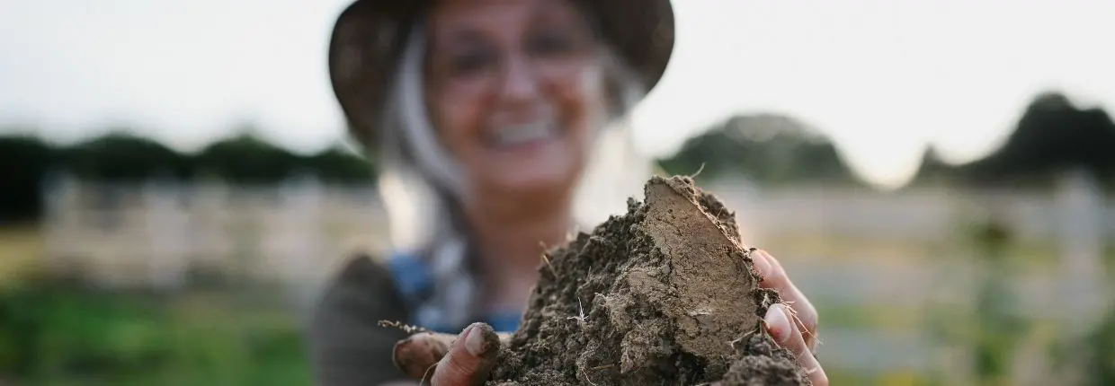 Suolo e rotazione, una donna mostra della terra fertile