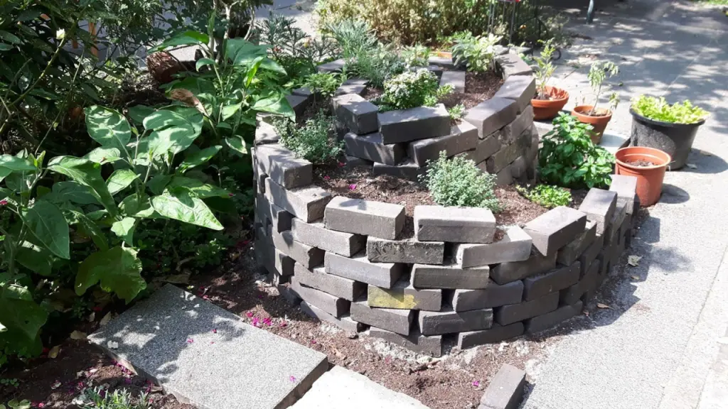 Un circular garden con piante aromatiche realizzato tramite le piastrelle recuperate