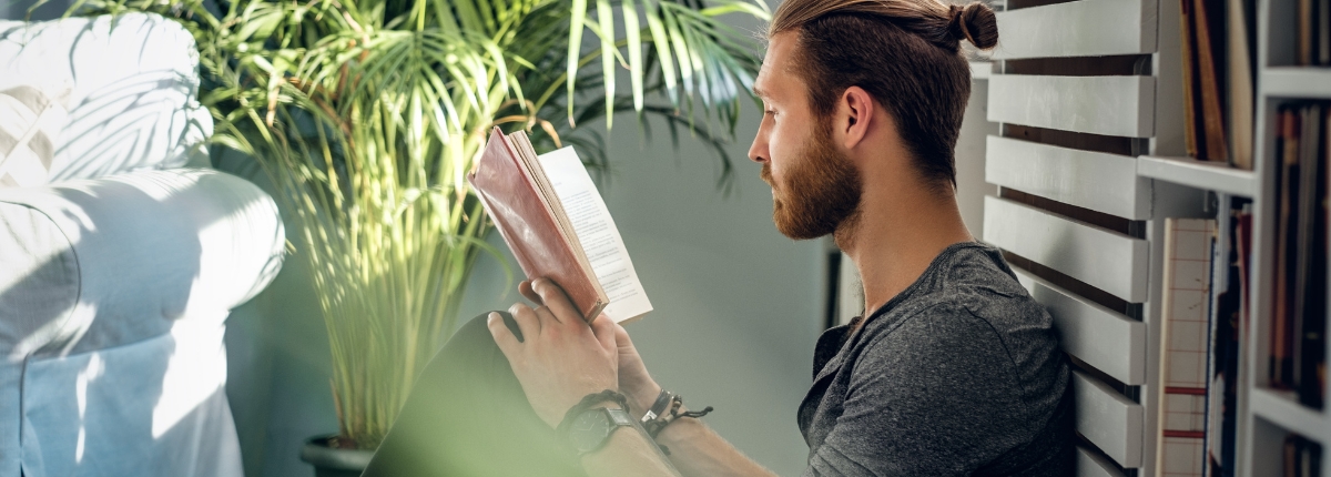 Bookcrossing d'estate, un ragazzo legge un libro all'aperto