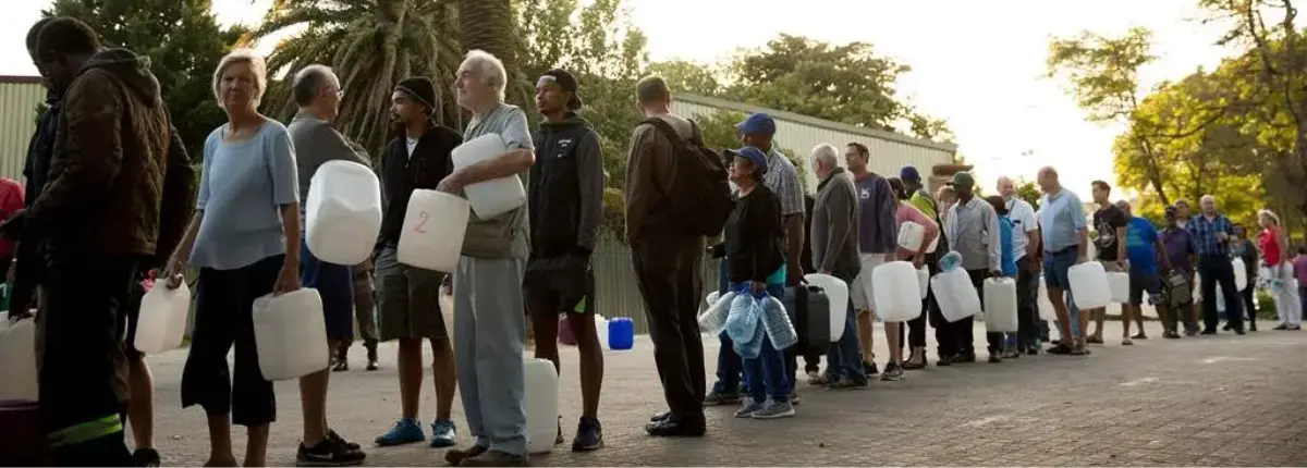 Fila di persone con le taniche per approvvigionarsi d' acqua, a Cape Town