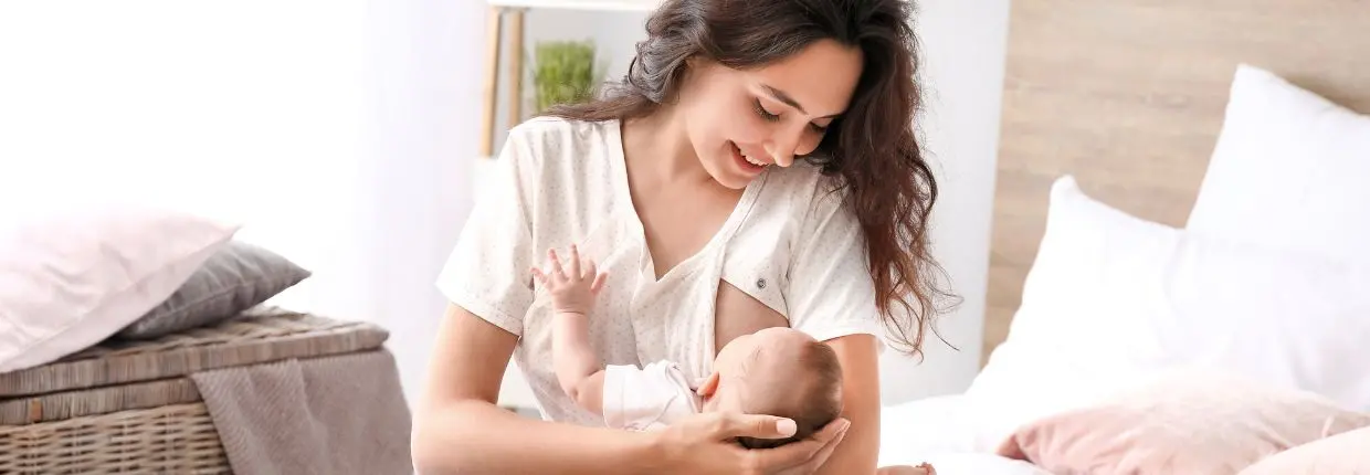 Vitamina D, sfida d'autunno: una donna allatta un neonato