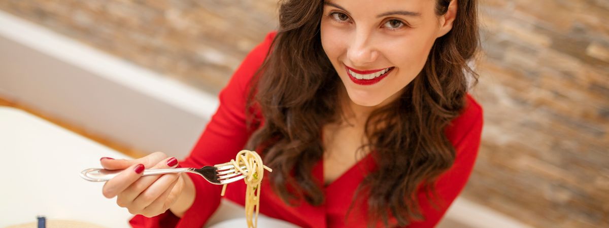 Una ragazza mangia degli spaghetti, come interagiscono peso forma e dna?